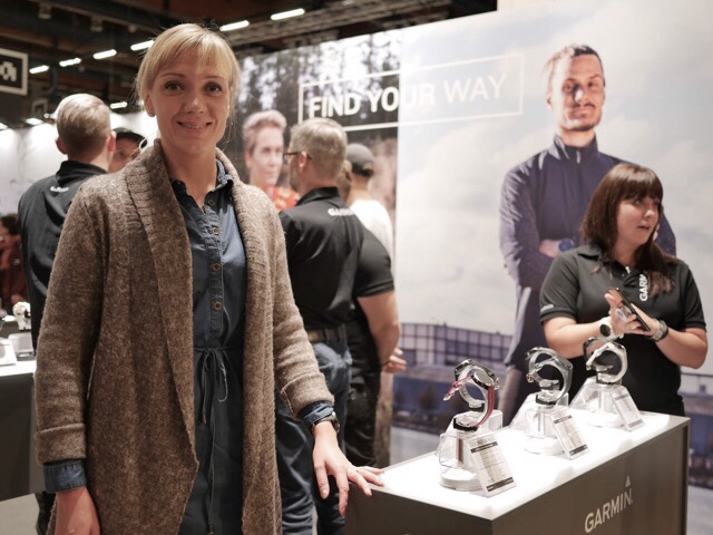 Kuva, jossa nainen nojaa standiin.