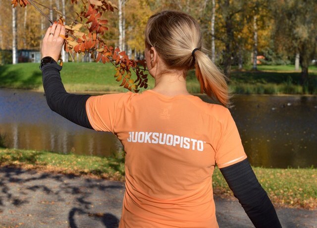 Kuva, jossa nainen pitelee puunoksaa.