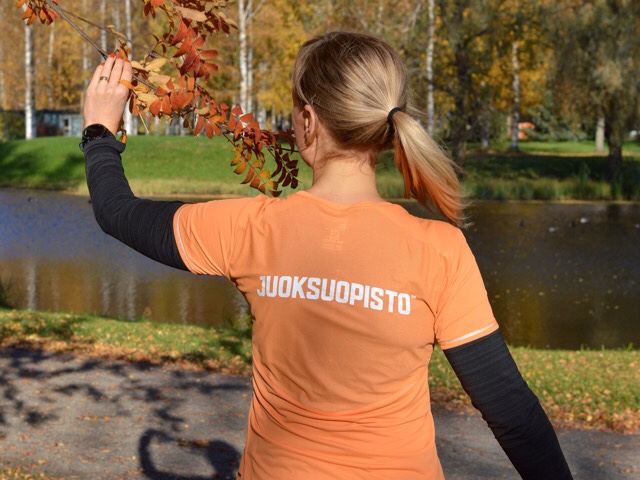 Kuva, jossa nainen pitelee puunoksaa.