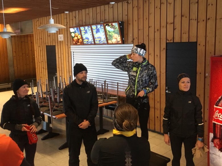 Kuva, jossa juoksuvalmentaja korokkeella.