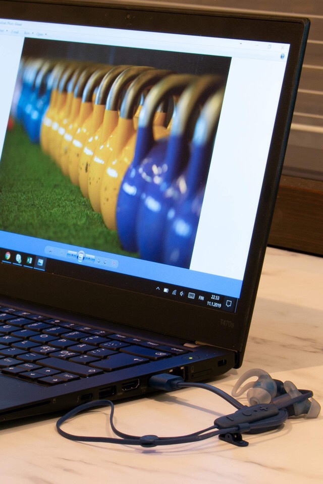 Kuva, jossa ladataan bluetooth kuulokkeita.