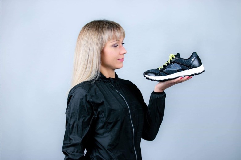 A woman looking at the shoe.