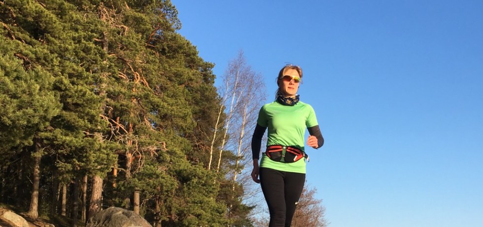 Kuva, jossa nainen juoksija juoksee rannalla.