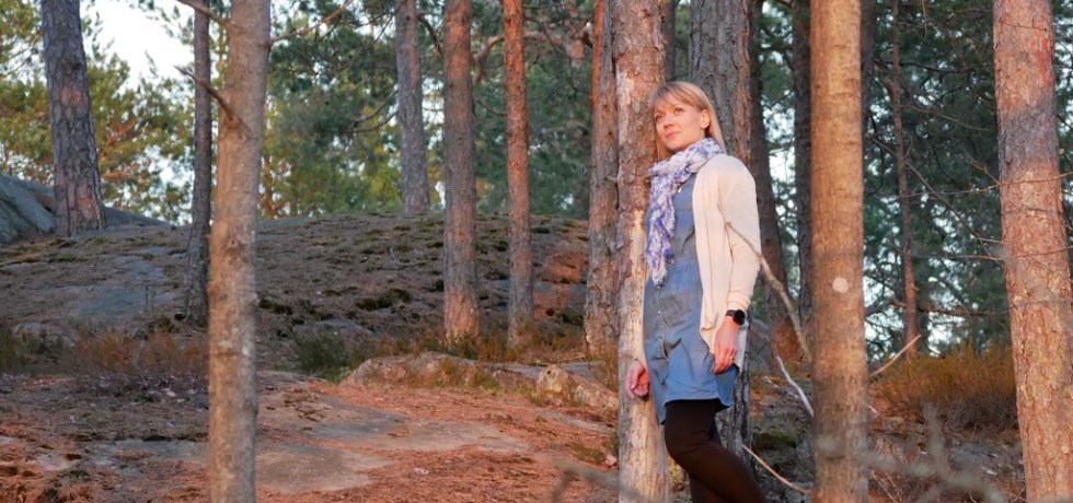 Kuva, jossa nainen ihailee auringonlaskua