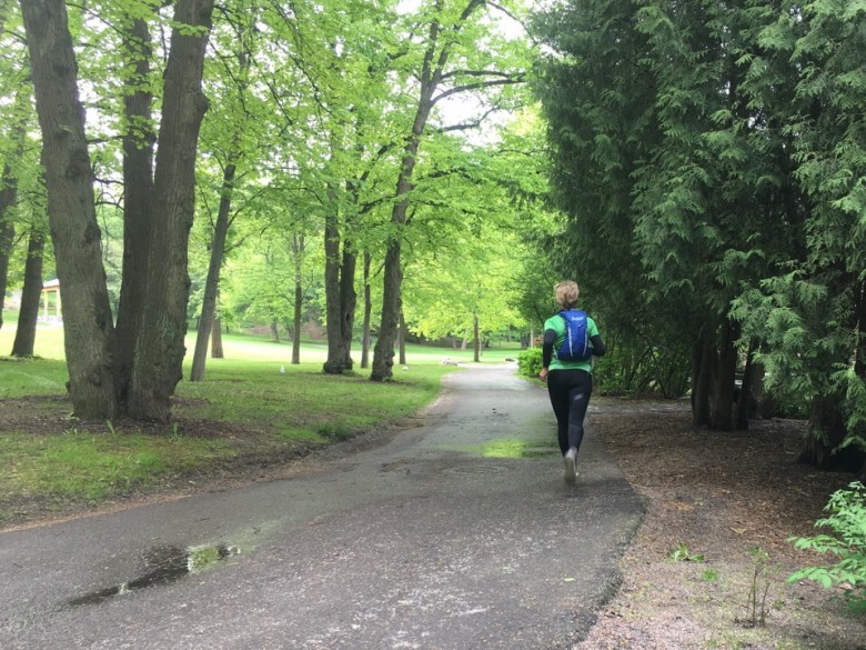 Kuva, jossa juoksija puistossa.