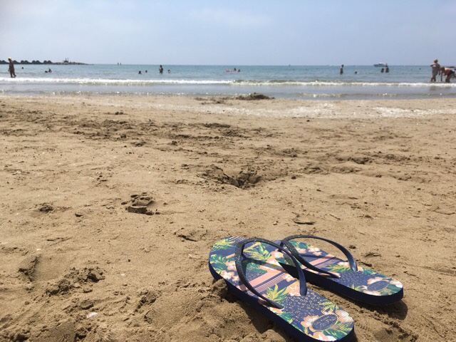 Kuva, jossa varvassandaalit rannalla