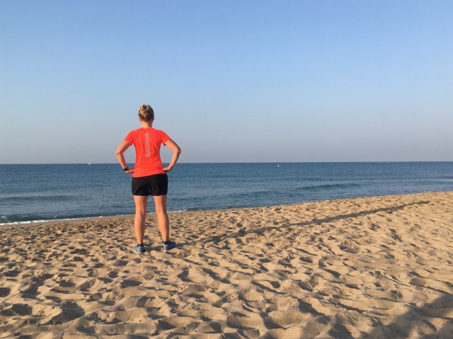 Kuva, jossa juoksija meren rannalla.