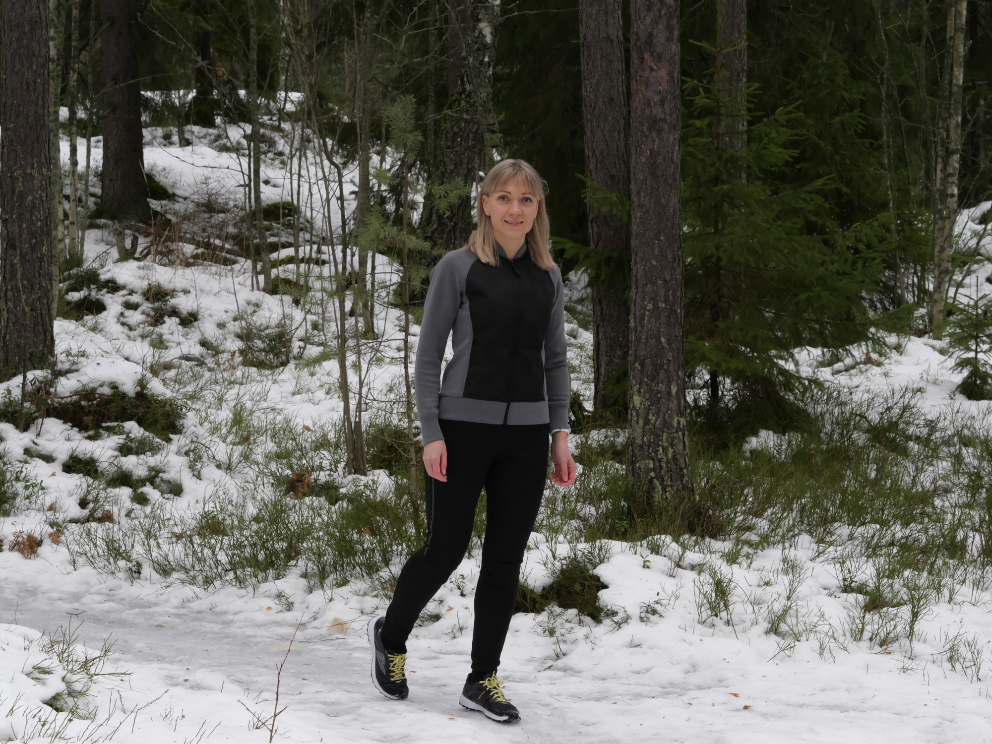 nainen kavelee jaisella polulla metsassa