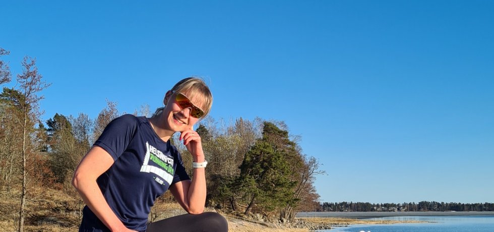 juoksija istuu kivella helsinki city running day paita paalla