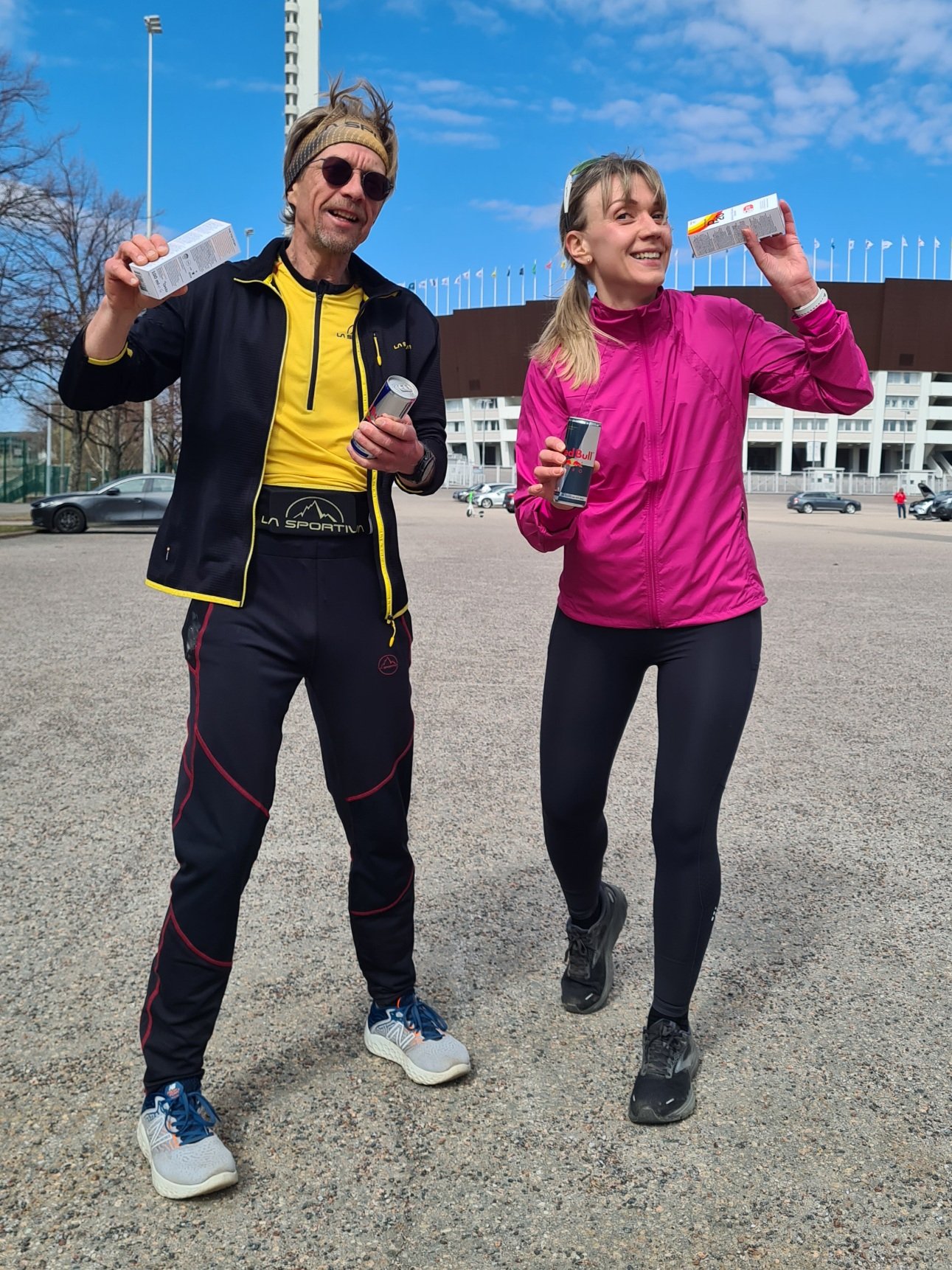 kaksi juoksijaa helsingin olympiastadionin edessa