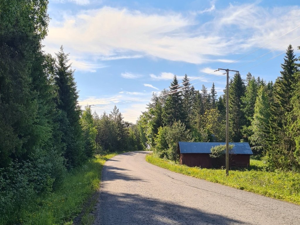 asfalttitie kiemurtelee maalaismaisemassa