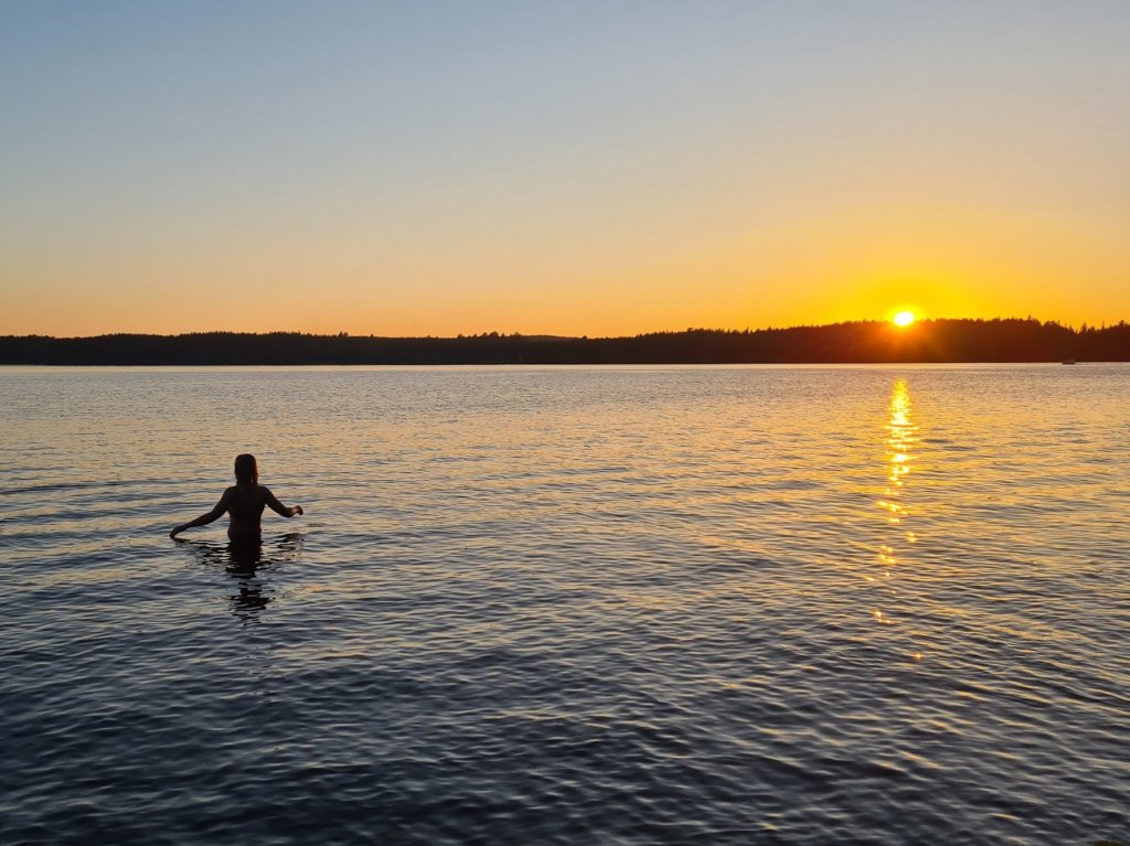 uimassa auringonlaskun aikaan
