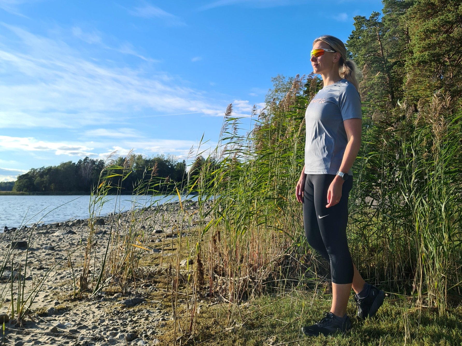 juoksija seisoo rannalla ja katsoo merelle