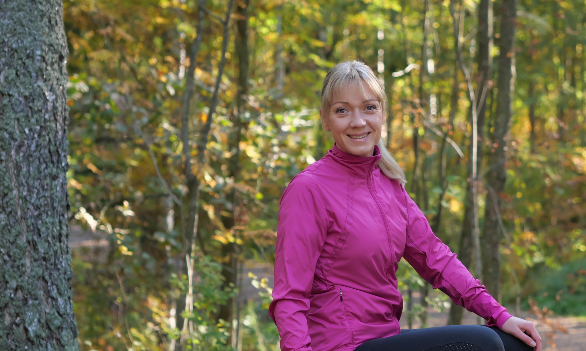 pinkki juoksutakki ja mustat juoksutrikoot