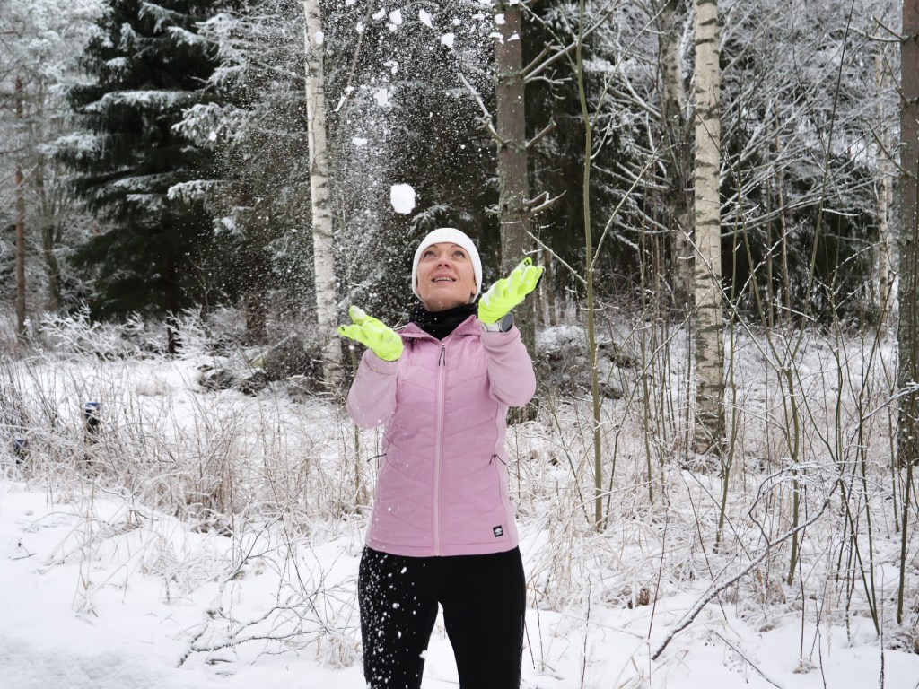 nainen heittaa pakkaslunta ilmaan