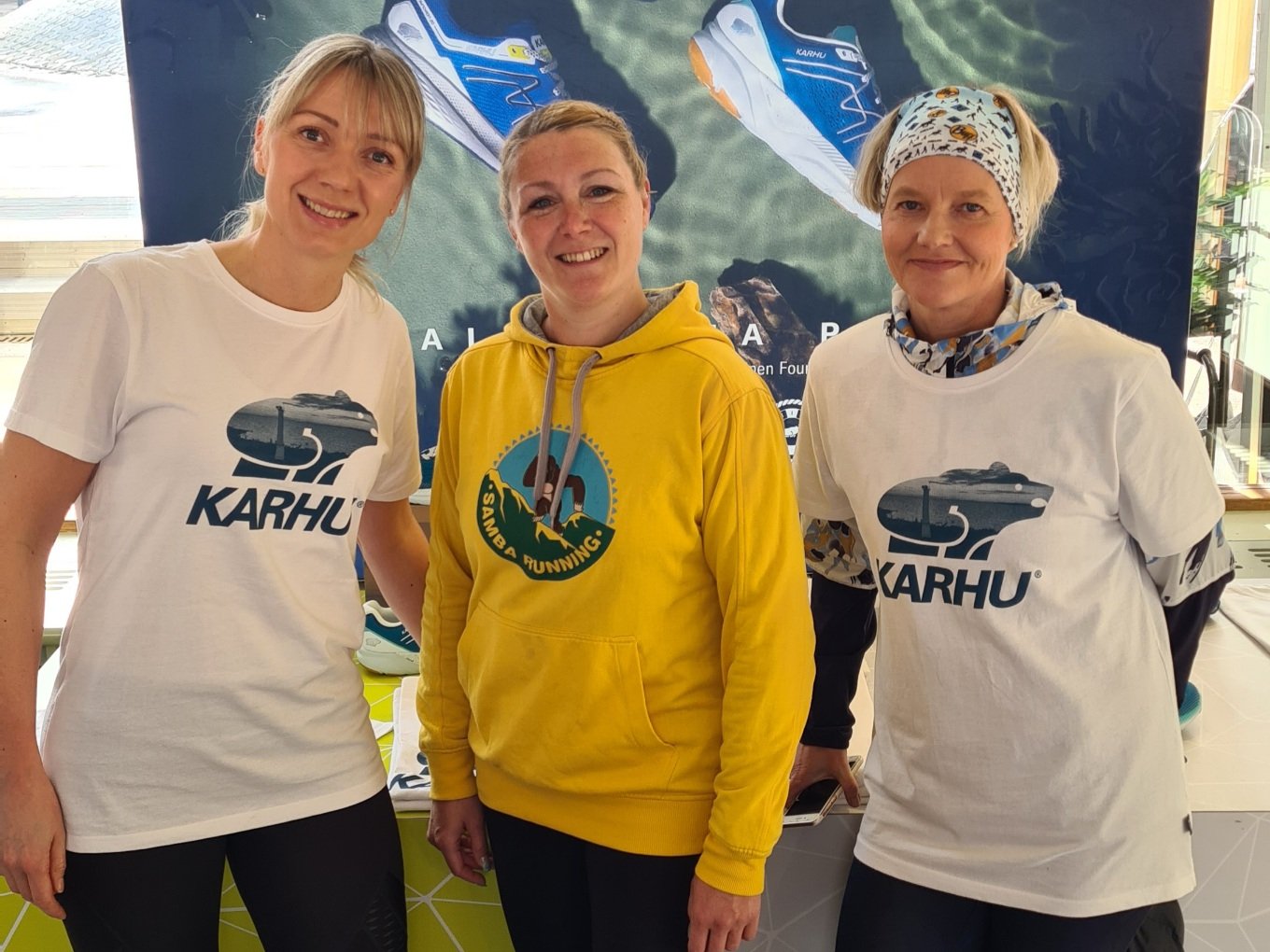 kolem juoksijaa katsovat kameraan ja hymyilevat