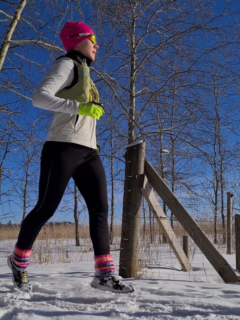 juoksija juoksee talvisella polulla molemmat jalat ilmassa