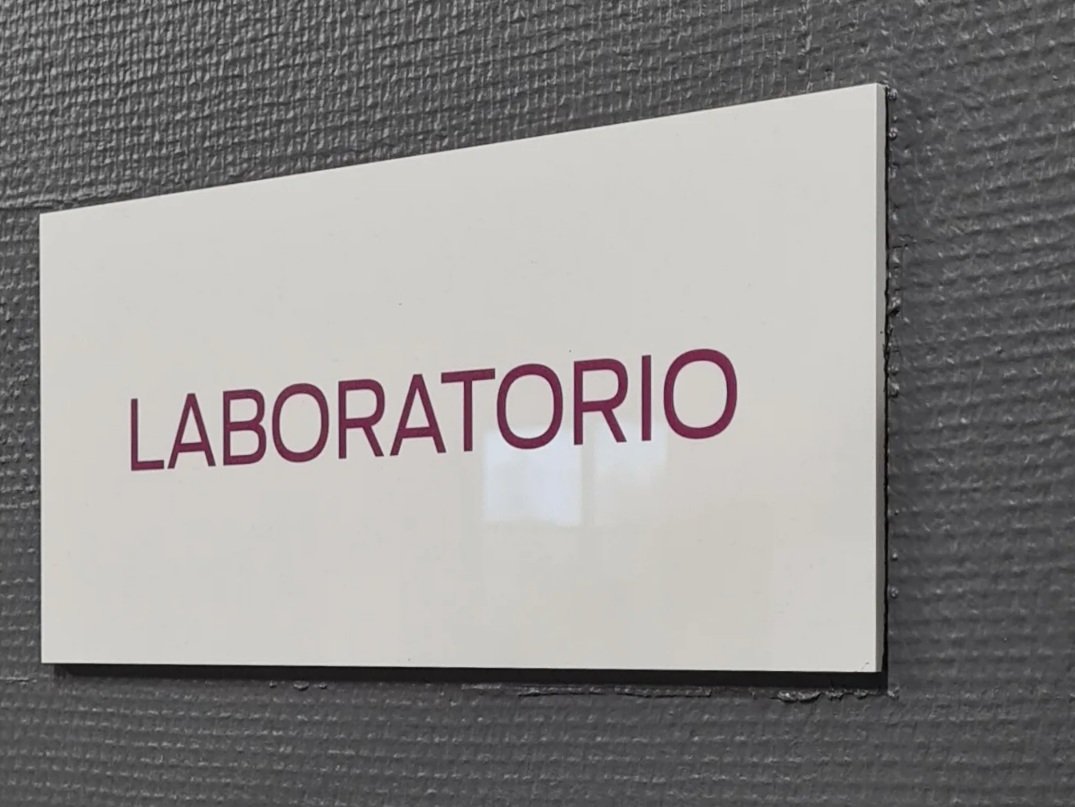 valkoinen laboratorio kyltti harmaalla seinalla