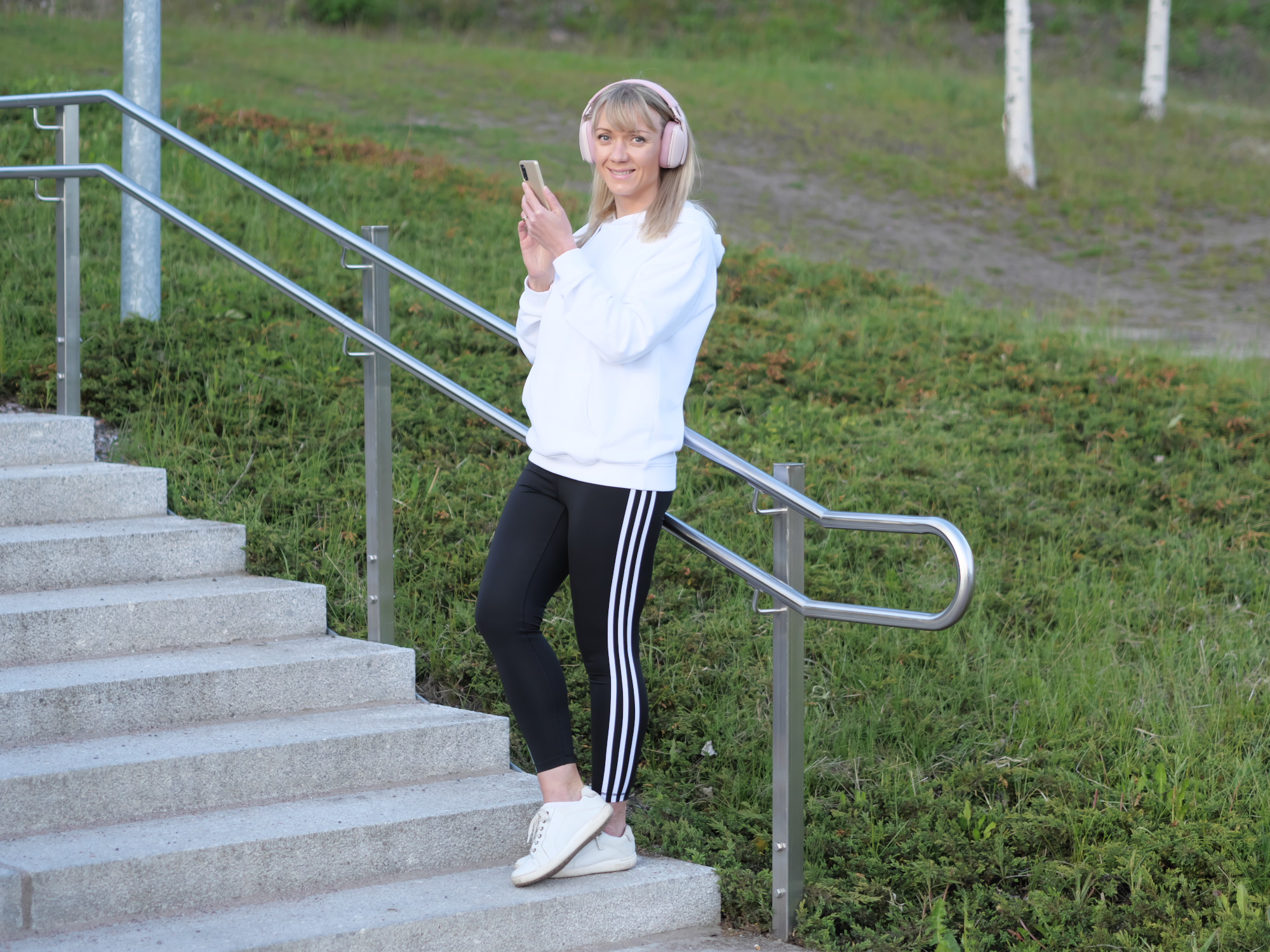 nainen puhelin kadessaan katsoo kameraan pain