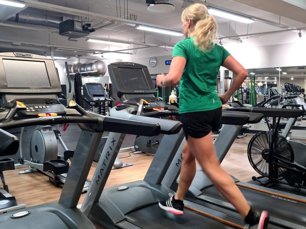 nainen juoksee juoksumatolla