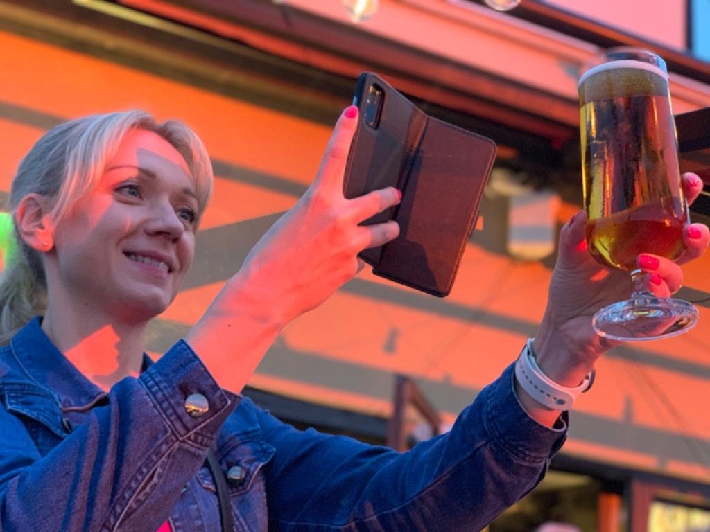 nainen kuvaa kannykallaan olutlasia