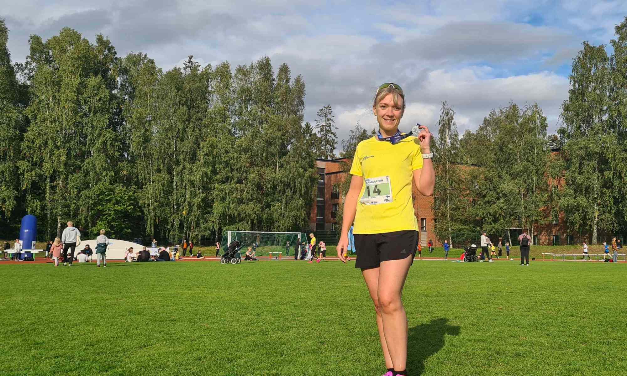 juoksija seisoo otaniemen kentalla ja pitelee mitalia kadessaan