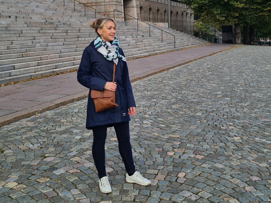 nainen seisoo eduskuntatalon edessa