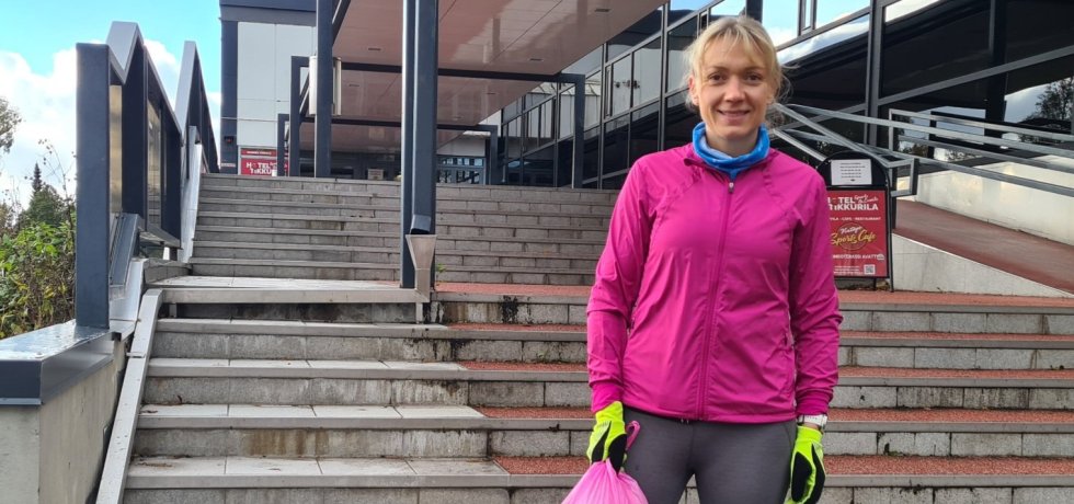 juoksija seisoo roskapussin kanssa portailla