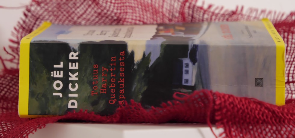 kirja makaa hyllylla punaisen kankaan paalla