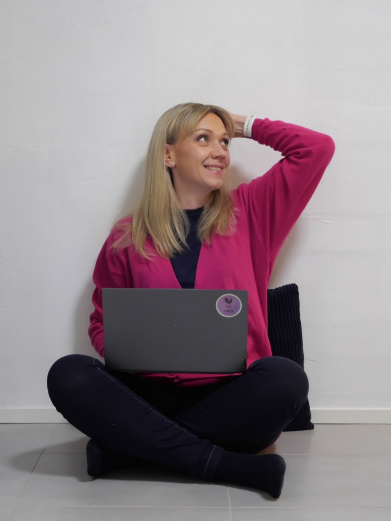 nainen istuu lattialla tietokone sylissa