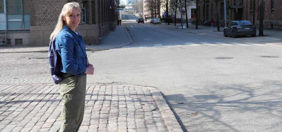 nainen seisoo kadulla helsingin katajanokalla ja taustalla nakyy tuomiokirkko