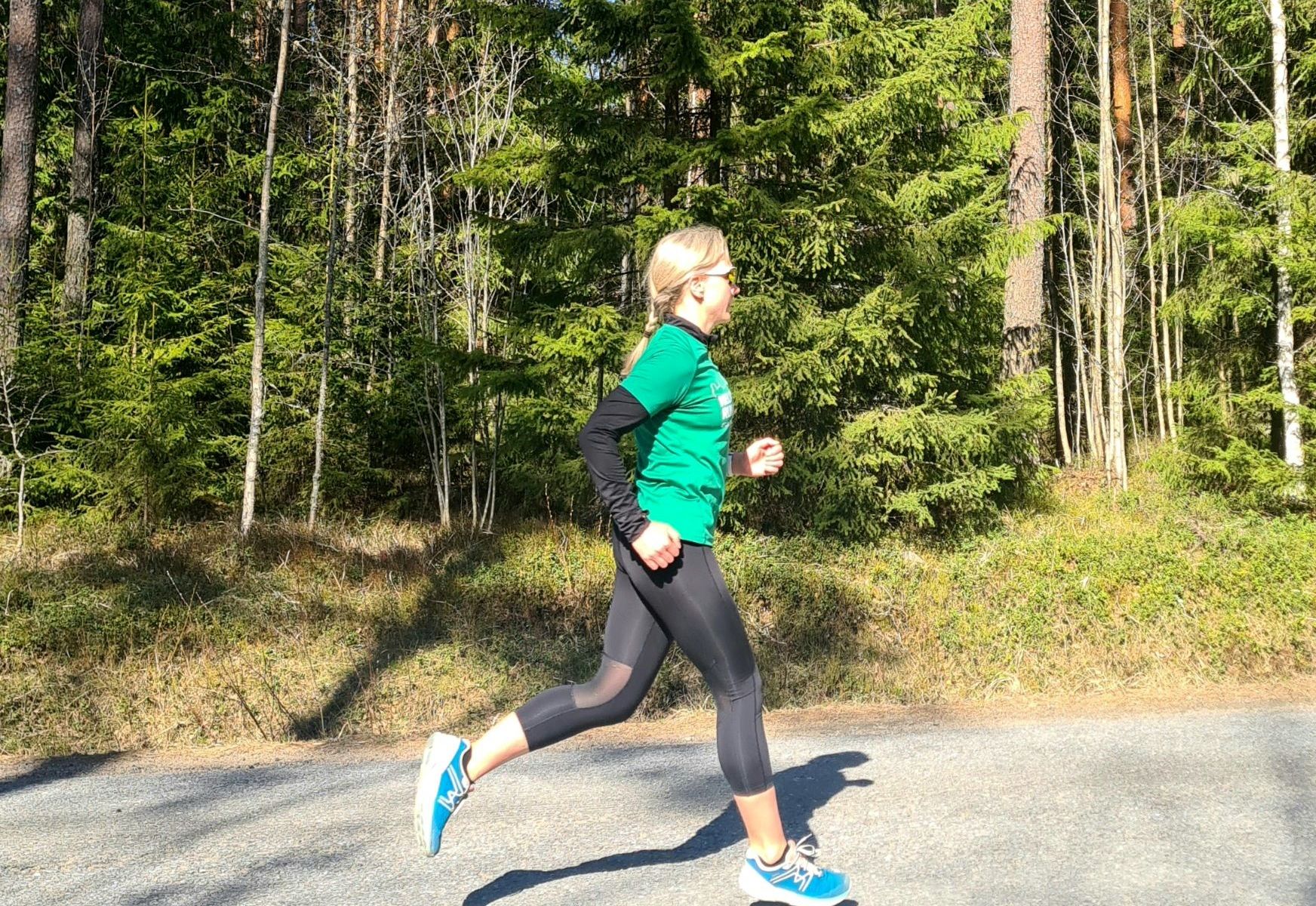 juoksija jolla vihrea paita ja mustat trikoot