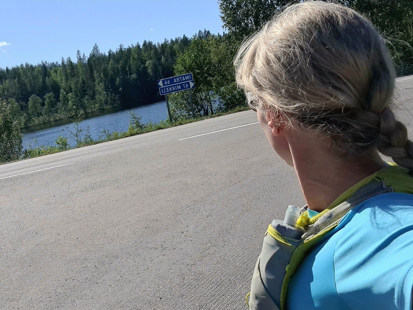 juoksija katsoo kilometrikylttia