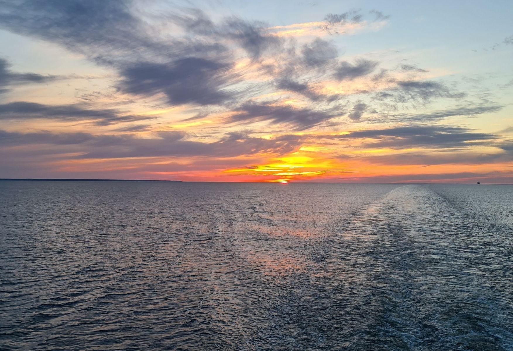 aurinko laskee kesakuussa suomenlahdella ja taivas varjaytyy oranssiksi