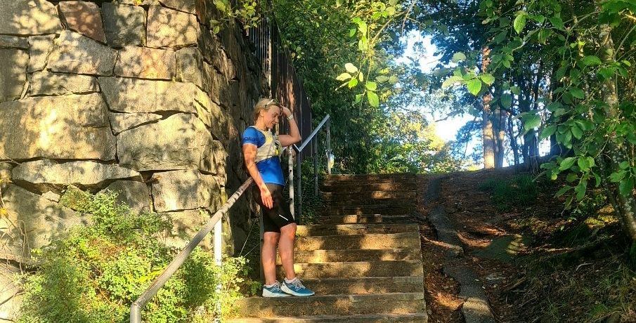 a woman runner standing on stone steps