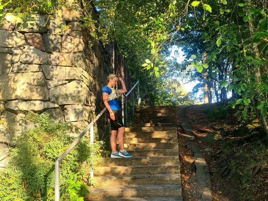 a woman runner standing on stone steps