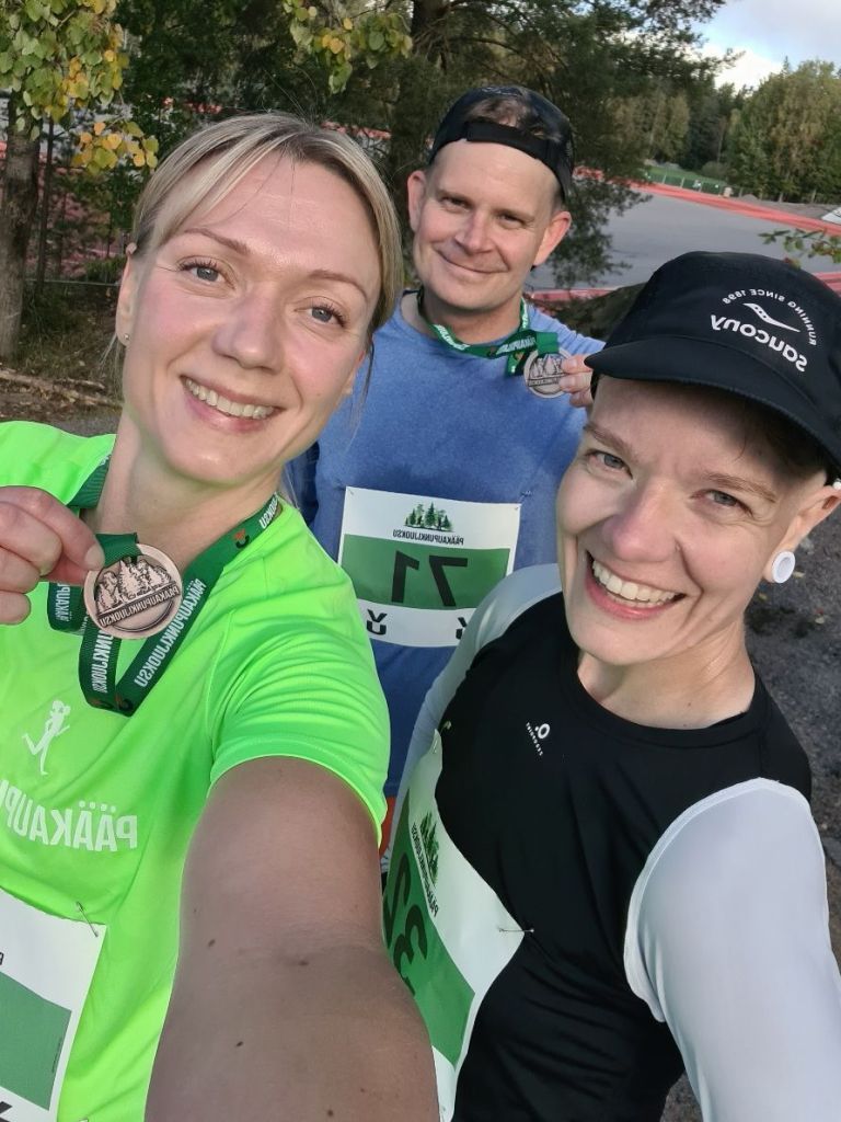 three half marathon runners two of them with a participant medal