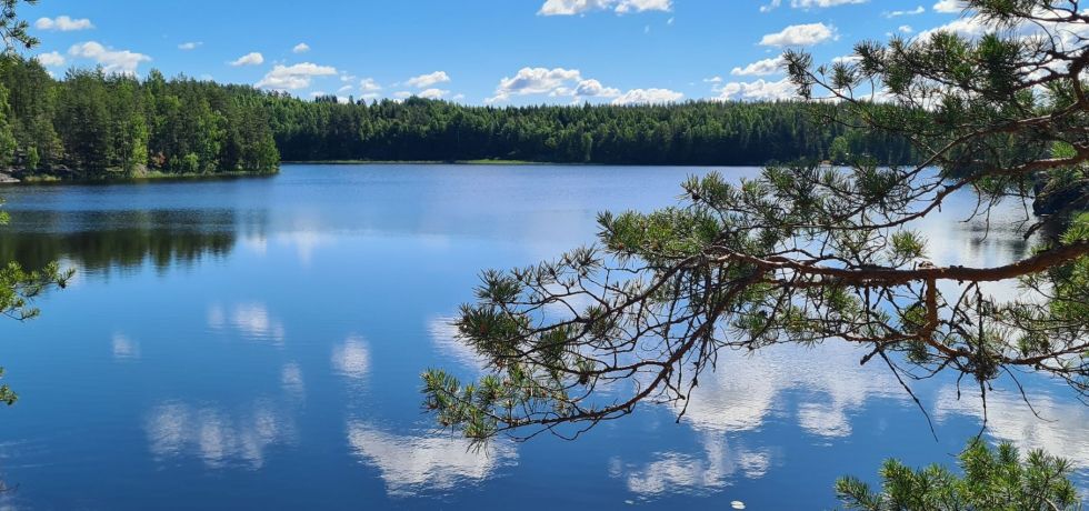 valkoiset pilvet heijastuvat sinisen jarven pinnasta