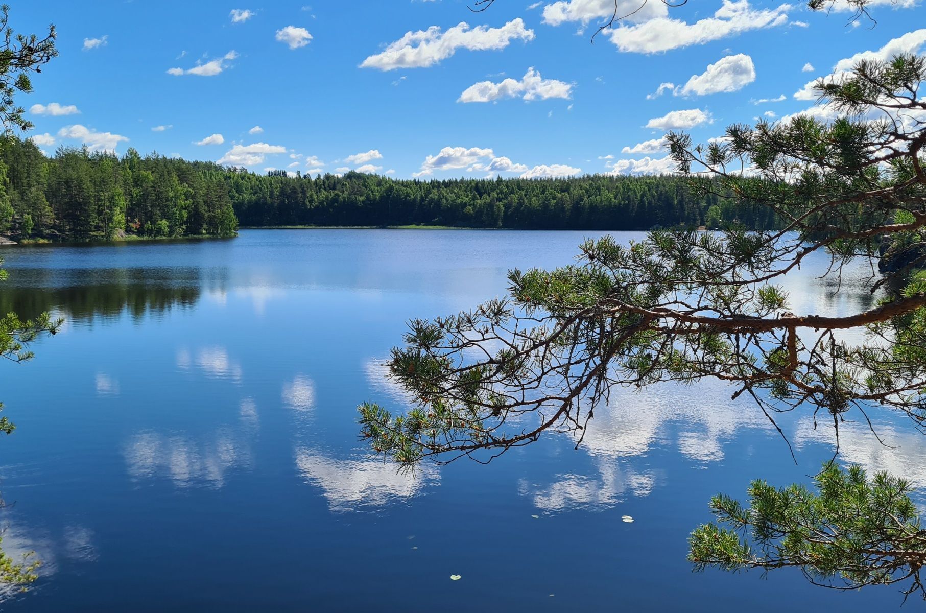 valkoiset pilvet heijastuvat sinisen jarven pinnasta