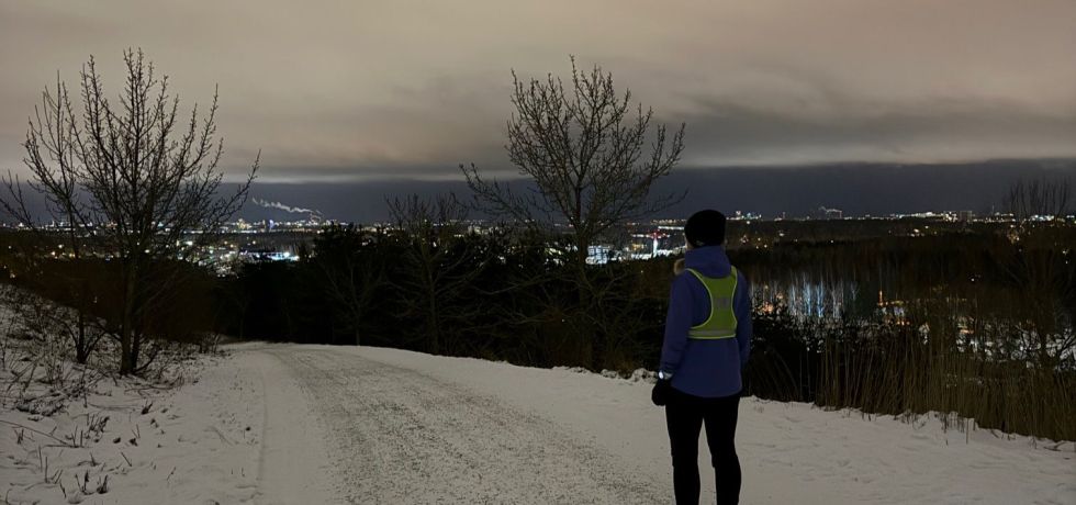 juoksija katselee maisemia malminkartanon jatemaen paalta helsingin suuntaan
