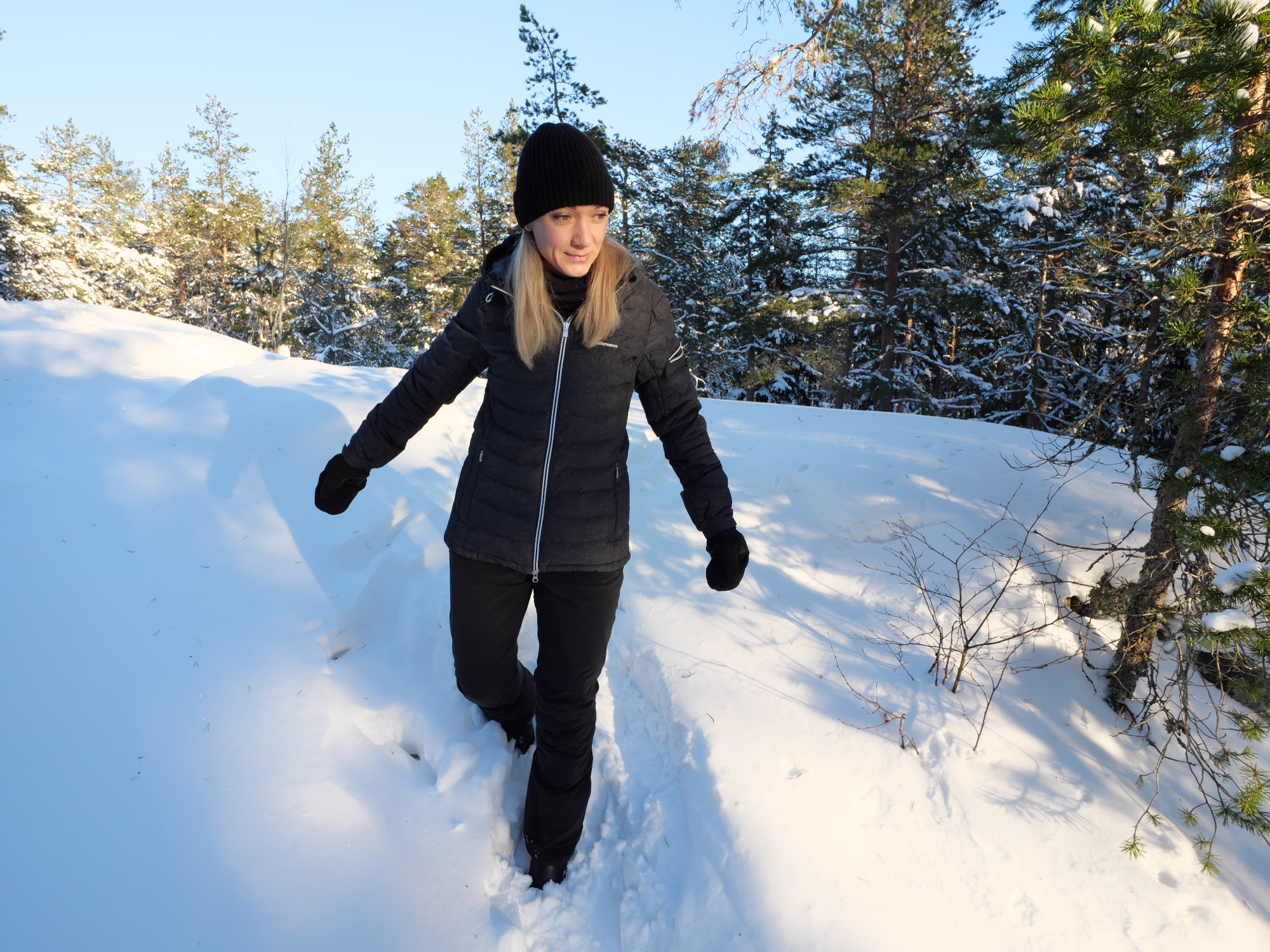 nainen kavelee talvisessa metsassa
