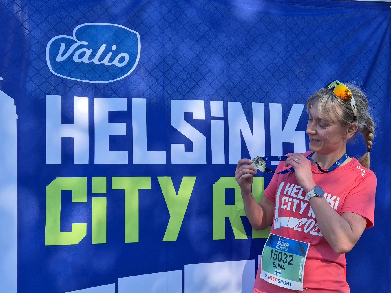 juoksija osallistujamitalin kanssa