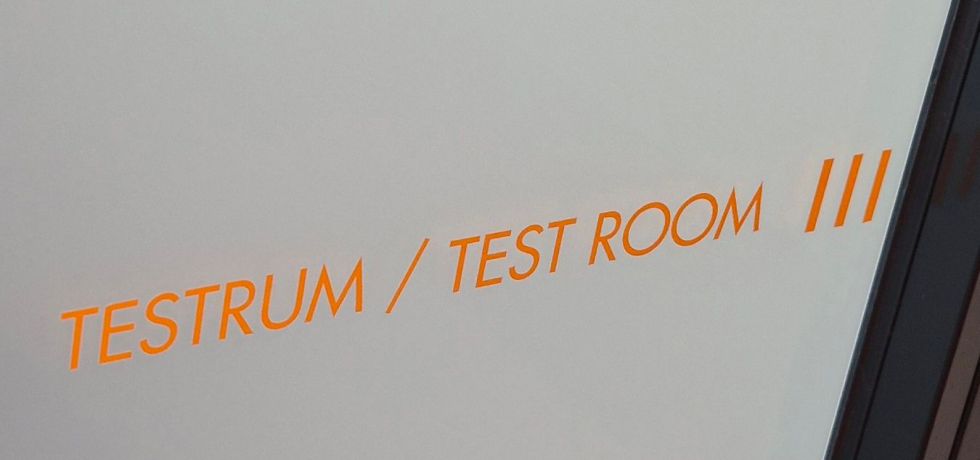 teksti testaushuoneen ovessa