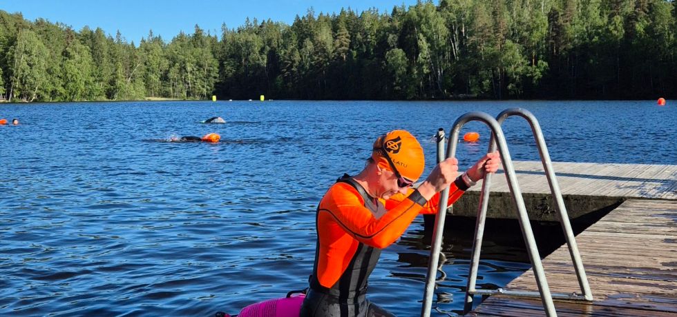 nainen nousee markapuku paallaan vedesta laiturille