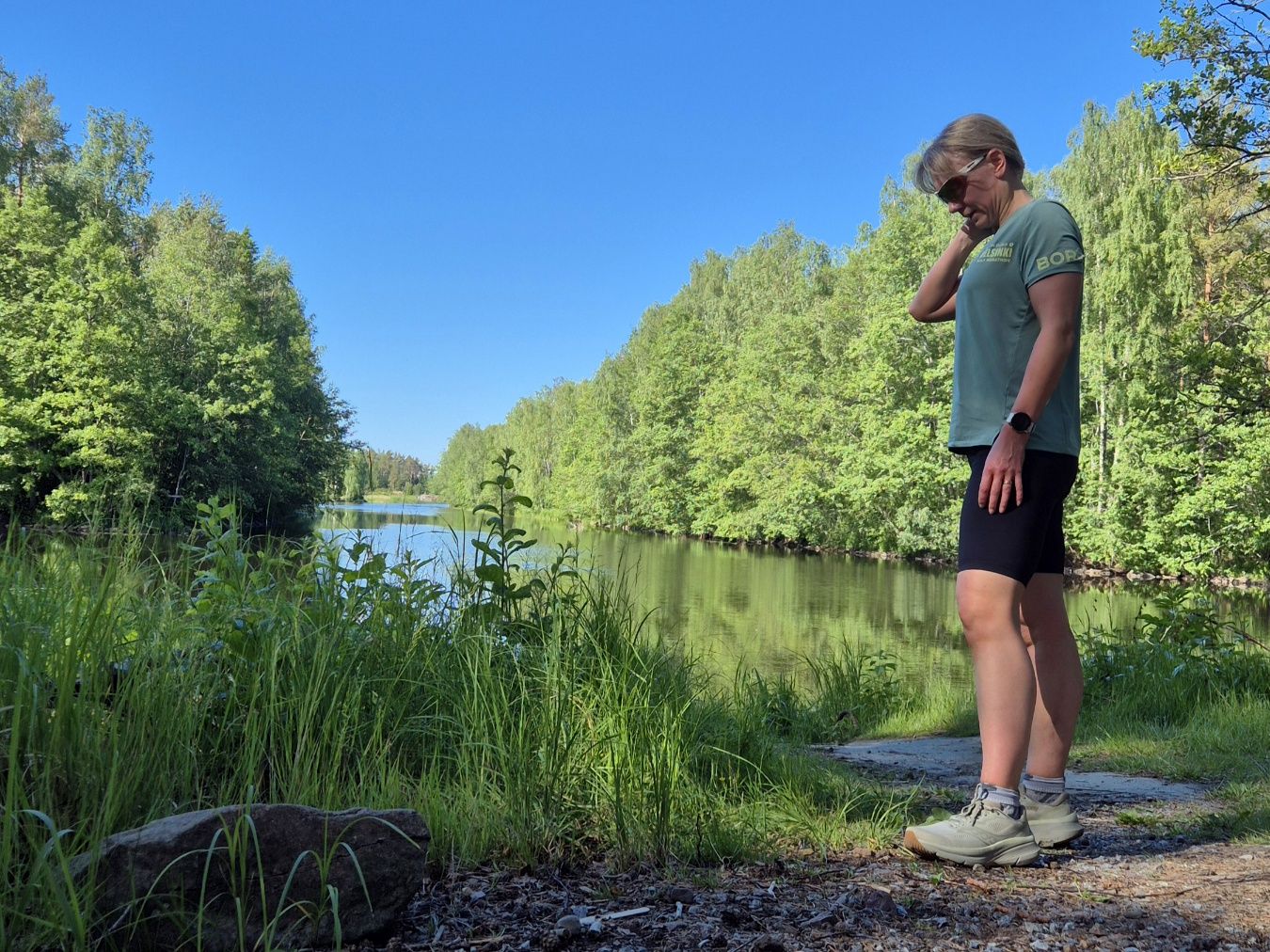 nainen seisoo lenkkivaatteissa murtovetta taustalla
